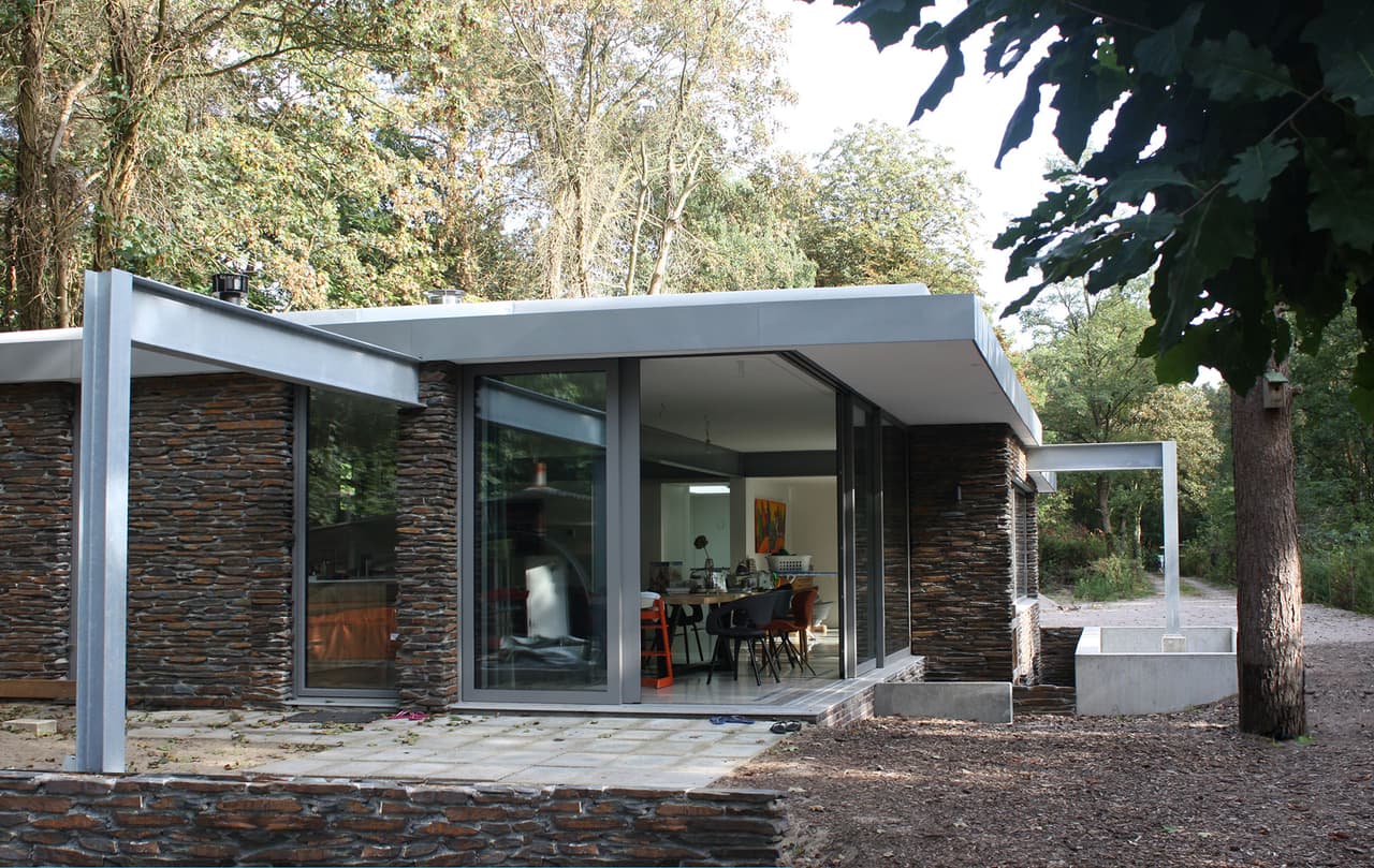 De open hoek van de bungalow laat het boslicht binnen